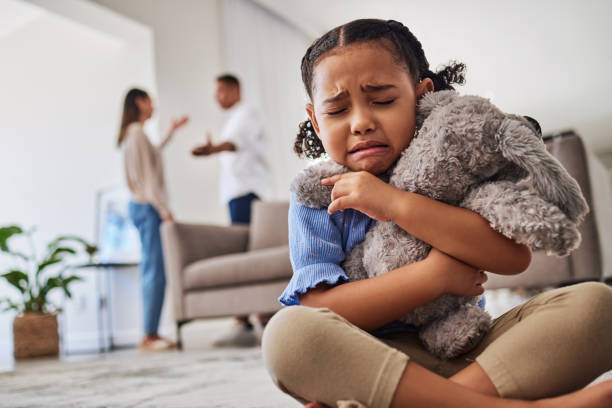 triste, menina e chorando de briga de pais, discussão ou divórcio abraçando pelúcia em casa. criança pequena infeliz em depressão, estresse e ansiedade de mãe e pai lutando em desacordo familiar - child grief mourner disappointment - fotografias e filmes do acervo