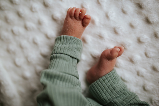 Close-up shot of a baby's feet on a white blanket