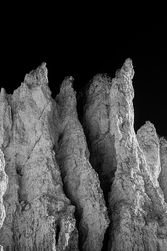 Bright Light Reflects Off Hoodoos Against Black Sky with contrast effects