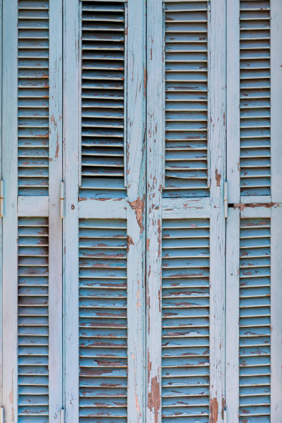 istock Antique turquoise painted wooden shutter with cracked paint. 1446749614