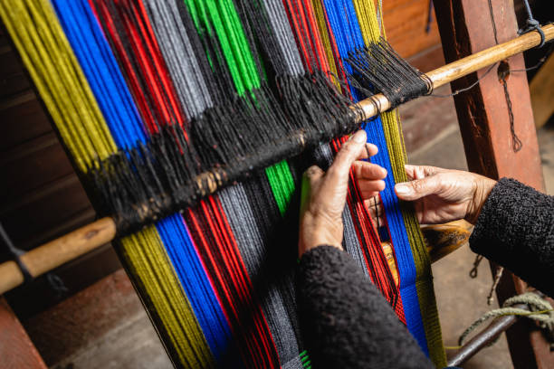 istock Unrecognizable elder woman's hands using a homemade craft loom to weave colorful wool 1446749920