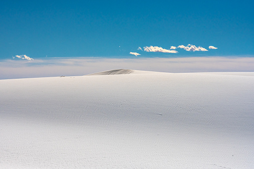 White Sands NP, New Mexico, USA - May 31, 2021: Female tourist is climbing sand dune in White Sands National Park in New Mexico, USA.