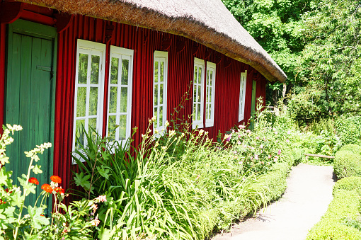 a garden in front of a red wooden house
