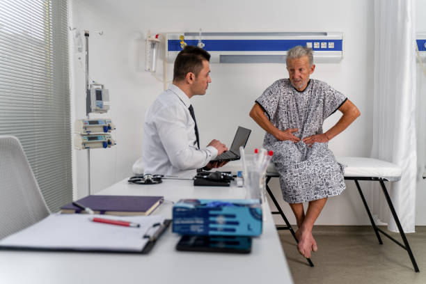 doctor listens intently to her senior male patient - doctor patient male tongue depressor imagens e fotografias de stock