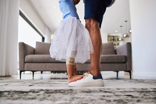 Feet, dance and girl dancing with father in a living room, love and family fun in their home together. Shoes, happy family and parent teaching child dancer, loving and caring support by single dad Feet, dance and girl and father dancing in a living room, love, family and fun in their home together. Shoes, happy family and parent teaching child dancer, loving, caring and support by single dad dancing dad stock pictures, royalty-free photos & images