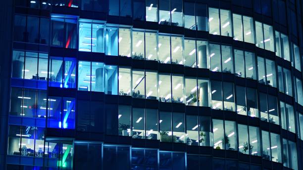 istock Pattern of office buildings windows illuminated at night. 1446753852