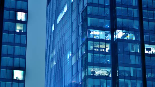 istock Pattern of office buildings windows illuminated at night. 1446753885