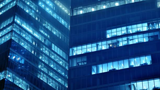 istock Pattern of office buildings windows illuminated at night. 1446753912