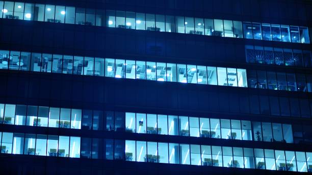 istock Pattern of office buildings windows illuminated at night. 1446753926