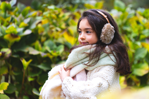 Little girl smiling in the winter, cold park