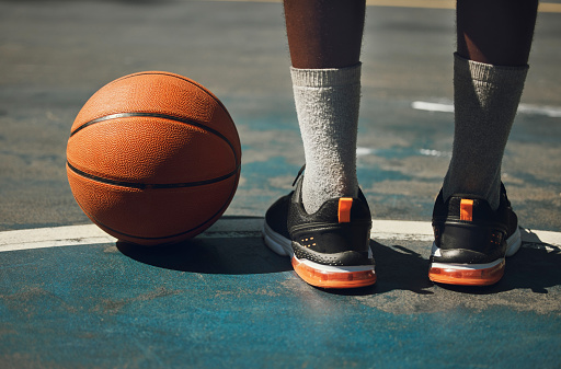 Basketball, basketball player and athlete legs close up on basketball court outdoors fitness training workout. Young African American man, sports exercise and healthy lifestyle motivation outside