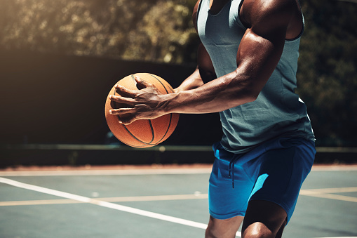 Man, basketball and running on court for training, workout and exercise in summer. Basketball player, basketball court and practice in sunshine for fitness. dribble or wellness to be ready for sports