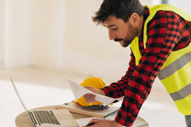 istock Construction worker trying to figure out blueprints 1446762959