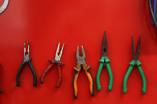 Set of work tools hanged on red background