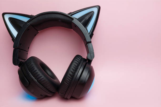 istock Black wireless headphones are highlighted on a pink background. Cosplay accessory. Wireless gaming headset with cat ear. Different colors of illumination. 1446765222