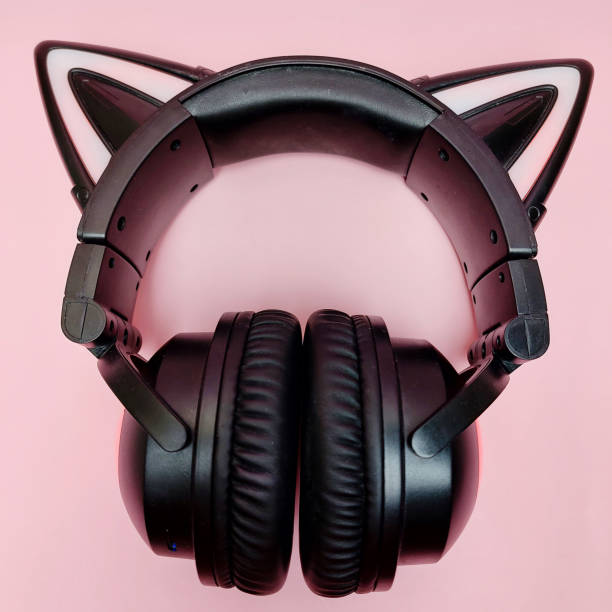 istock Black wireless headphones are highlighted on a pink background. Cosplay accessory. Wireless gaming headset with cat ear. Different colors of illumination. 1446765239