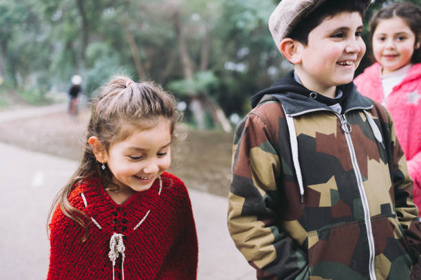 istock Three kids chatting while walking in a public park road 1446767447
