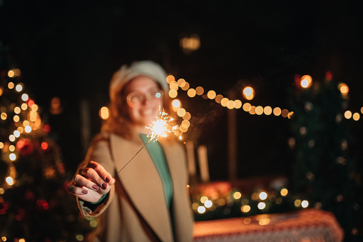 Woman holding a sparkler on Christmas eve, celebrating Christmas and New Years eve.