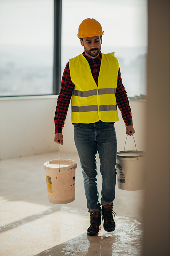 Construction Worker Carrying Buckets On Construction Site Stock Photo ...
