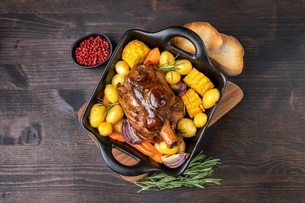 Pork meat shank with baked potatoes and corn Pork shank with baked potatoes and corn pork hock stock pictures, royalty-free photos & images