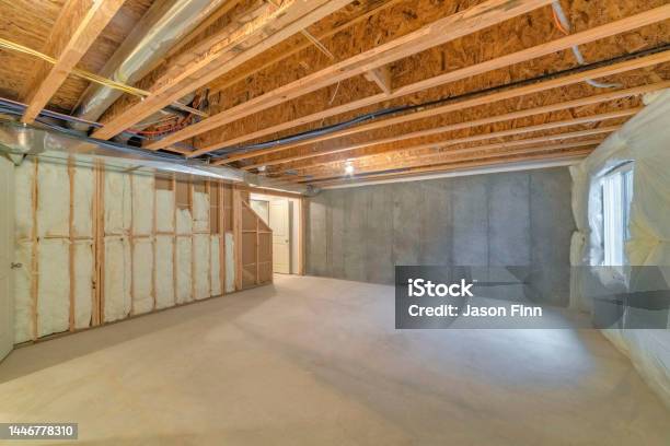 Unfinished Basement With A Plastic Vapor Barrier On The Wall Stock Photo - Download Image Now
