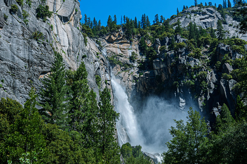 side view of Nevada Fall waterfall from Mist Trail in Yosemite National Park. Summer travel holidays in California, United States of America.