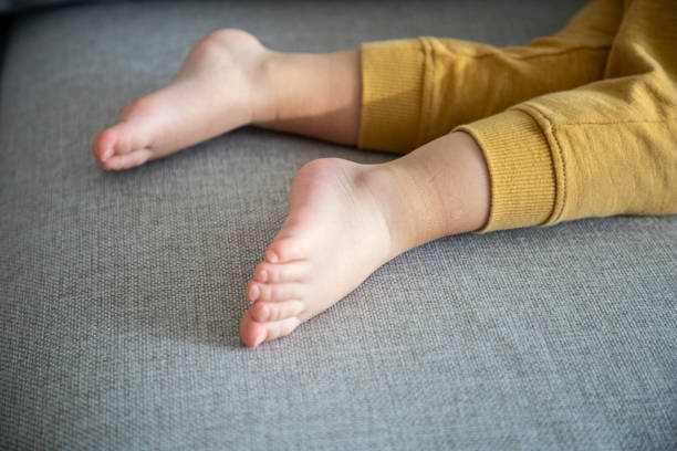 istock Kid's feet sleeping on the couch. Day nap, close up. 1446782033