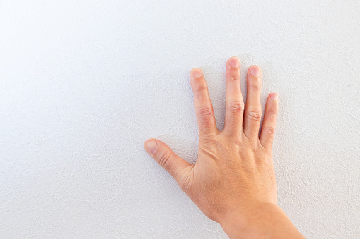 Right hand against white wall