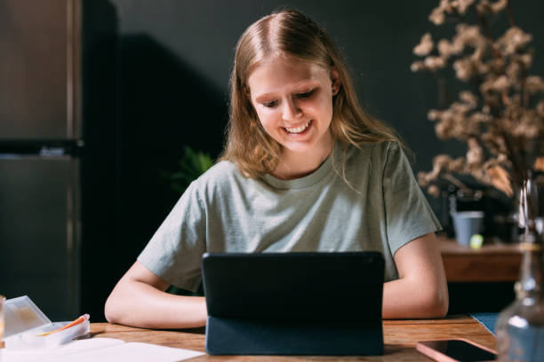 istock A Happy Beautiful Blonde Girl Learning Online Using Her Tablet While Relaxing At Home 1446787095