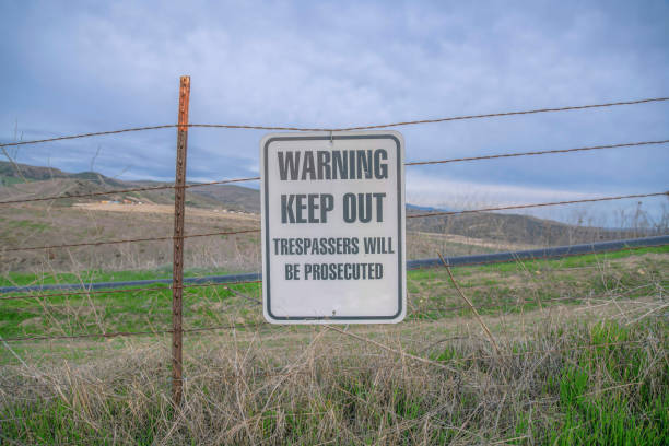 istock Hanging sign with Warning Keep Out Trespassers Will Be Prosecuted on a trail- San Clemente, CA 1446791465