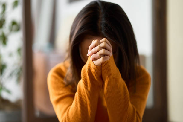 istock woman praying with her hands folded 1446791784