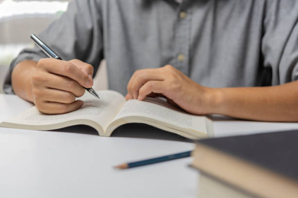 istock Businessperson reading and writing on book.education studying knowledge development and cognition learning concept. 1446796569