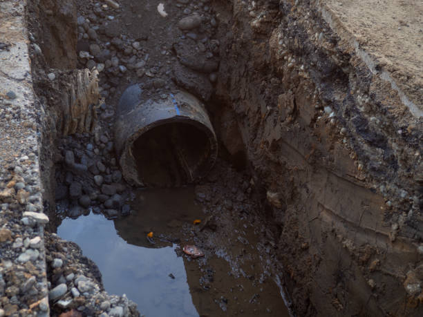 istock Works on the replacement of sewer pipes. Thick pipes underground. Earthworks with communications. Utility services. Sawn pipe. 1446799982