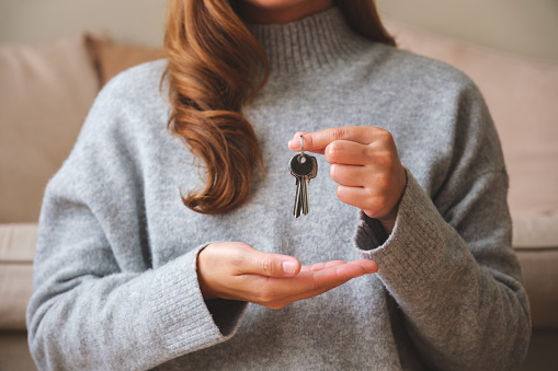 Primer plano de una mujer sosteniendo las llaves del concepto inmobiliario photo