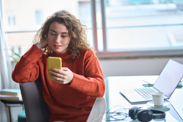 istock Young pretty woman using mobile phone while working at home. 1446806013