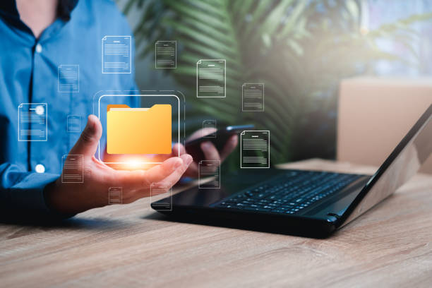 istock Document management system on concept virtual screen concept, Businessman use laptop and smartphone,show digital folder in hand,document storage system DMS online database management of company 1446810242