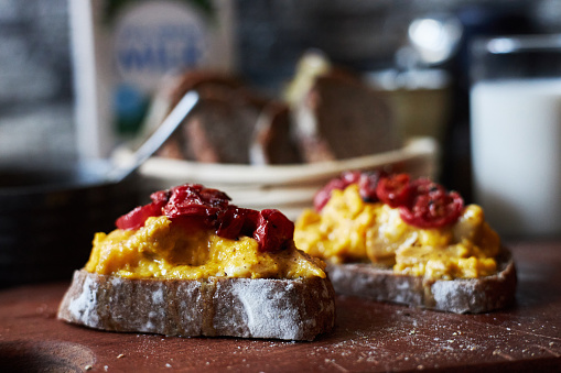Delicious Brunch Toast, topped with baked tomato and scrambled egg