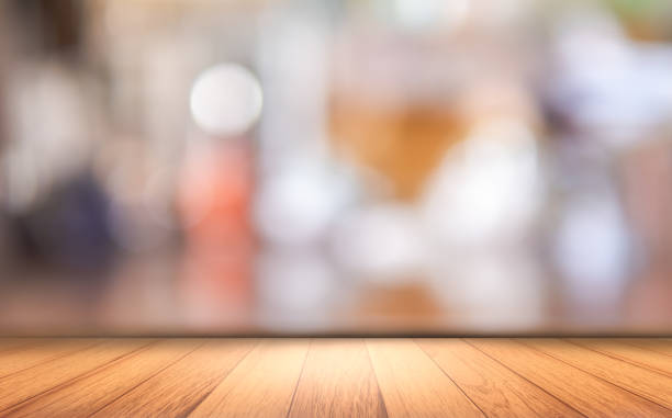 istock Wooden floor top table with soft light and blurred lighting backgrounds 1446812780