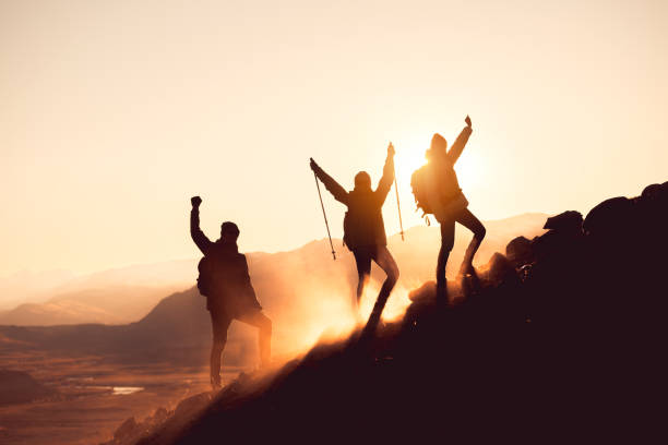 istock Three silhouette of hikers with raised arms 1446817617