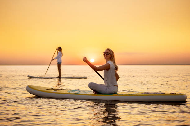 istock Two slim girls walks on sup boards 1446817658