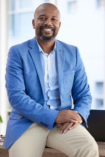Black man, entrepreneur and businessman success in a office with proud company vision. Startup boss, manager and leadership portrait of a senior ceo happy about working and workplace growth