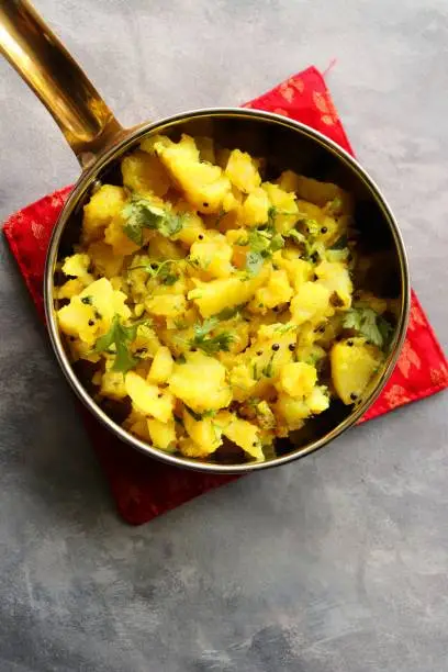 Indian boiled mashed potatoes curry or sabzi. Alu ki sukhi sabzi. Also known as Batatyachi suki bhaji in Marathi. ideal for puri bhaji or vada pav. Jeera aloo. copy space