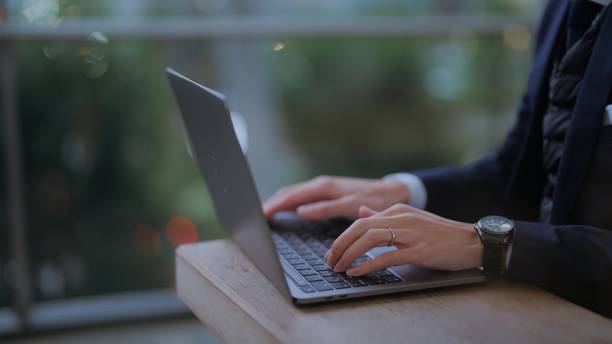 istock Businessman taking shelter from rain and using laptop in city 1446823937