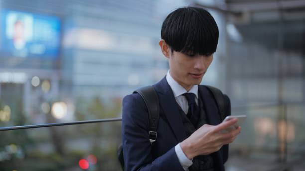 istock Businessman using smart phone in rain in city 1446824073