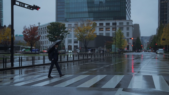 A businessman is commuting in the rain in the city.
