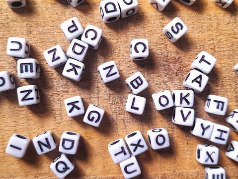messy dice or block letters over wooden background