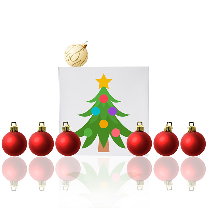Christmas present and red Christmas ornaments lined up on white background.