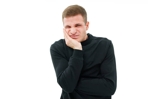 istock a man in a black robe holds on to his cheek on a white background. teeth hurt. 1446827404