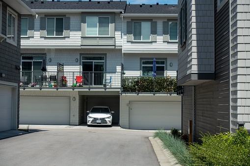 Surrey, Canada – November 24, 2022: A scenic view of Modern Townhouses with white car in the garage in Surrey, BC Canada