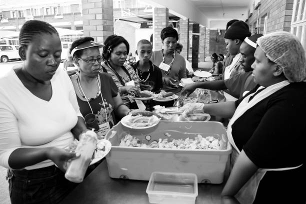 수프 키친 지역 사회 봉사 활동 케이터링 직원이 아프리카 여성을 위해 식사를 준비합니다. - dishing out 뉴스 사진 이미지